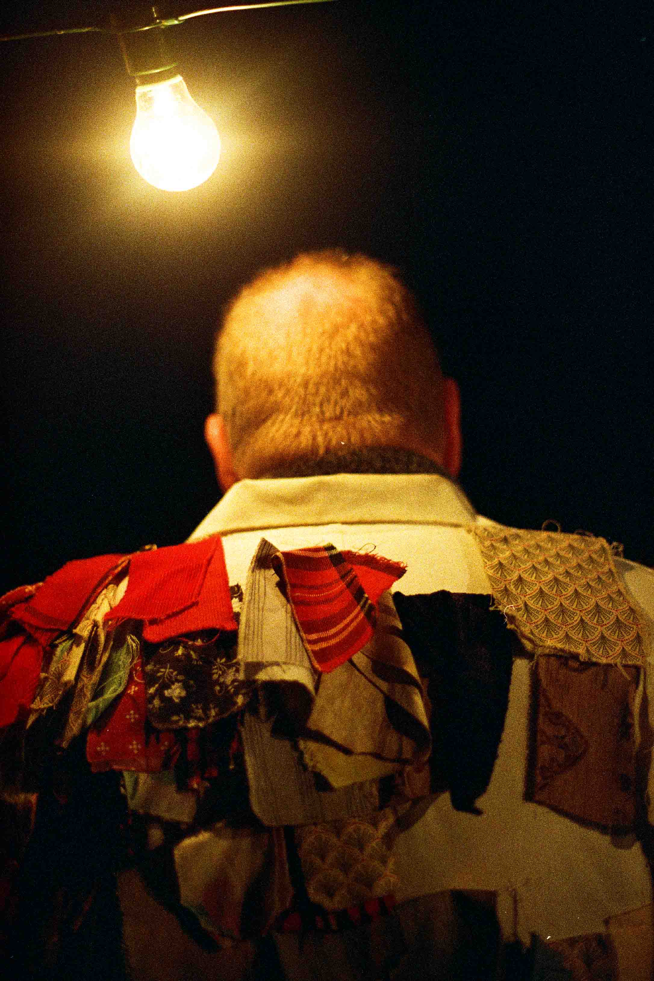 Rag coat morris man illuminated from behind by a bulb